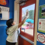 a person cleaning a door glass