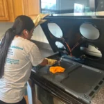 a person thoroughly cleaning the stove top
